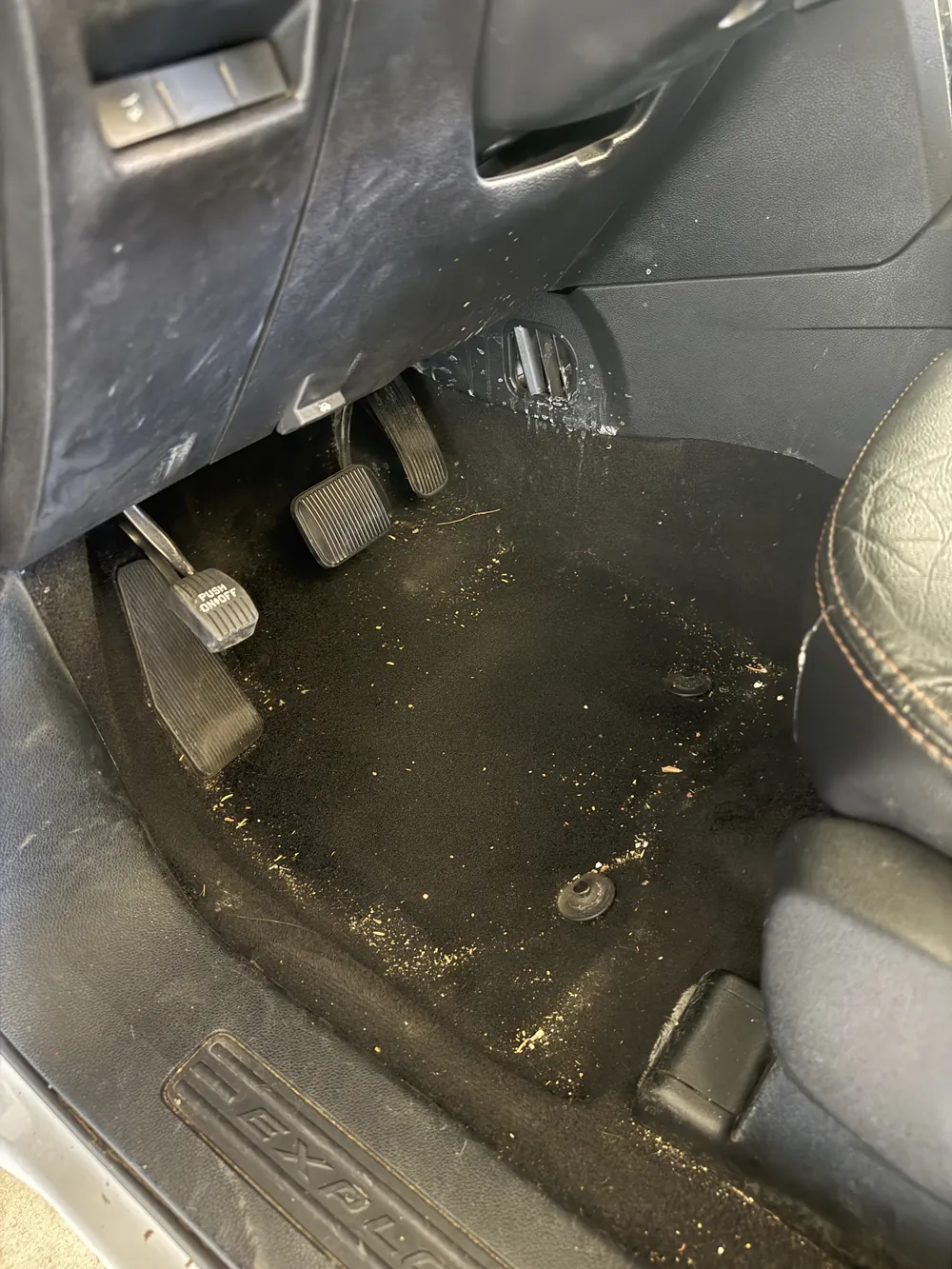 Footwell and pedals before — dirt across the carpet and console